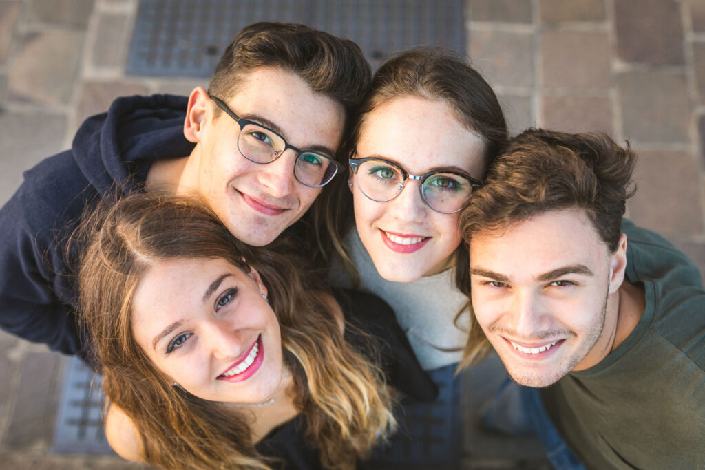 four young people are taking selfie.
